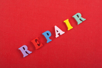 REPAIR word on red background composed from colorful abc alphabet block wooden letters, copy space for ad text. Learning english concept. - 798134941