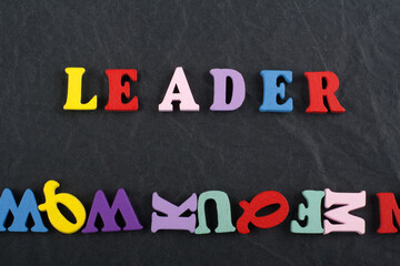 LEADER word on black board background composed from colorful abc alphabet block wooden letters, copy space for ad text. Learning english concept. - 798134952