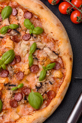 Delicious pizza with sausage, cheese, tomatoes, salt, spices and herbs
