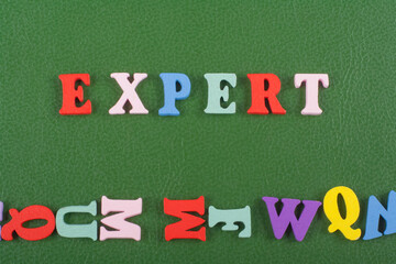 EXPERT word on green background composed from colorful abc alphabet block wooden letters, copy...