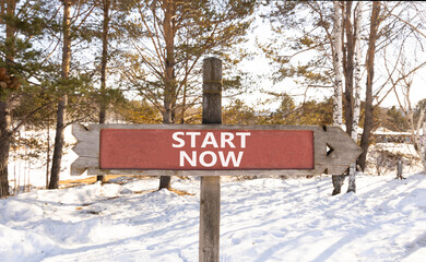 Start now symbol. Concept words Start now on beautiful wooden road sign. Beautiful forest snow blue sky background. Business marketing, motivational start now concept. Copy space. - Powered by Adobe