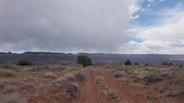 Driving through the desert on dirt road in Escalante Utah as storm rolls through.