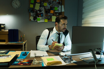 Investigator focused on gathering evidence, surrounded by case files and a cluttered desk at night