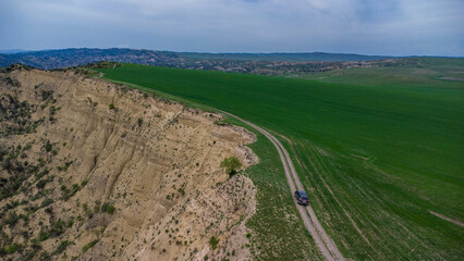 car are move in field near the canyon