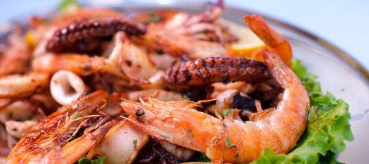 Close-up of pieces of squid, seafood with fried shrimp mixed with salad