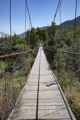 Pirque, Chile - 25 Nov, 2024: A suspension footbridge across a stream in the Maipo Valley,...