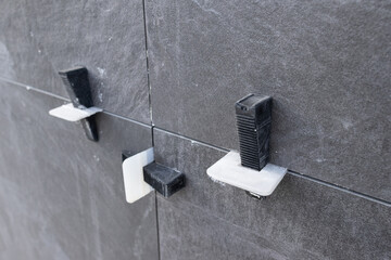 Close up of Plastic tile leveling system clips and wedges on Installed Ceramic tiles on construction site