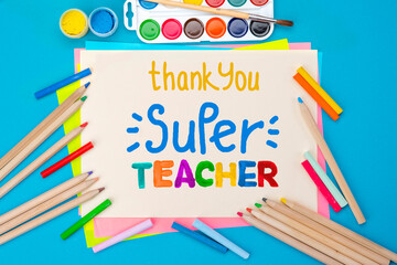 Childish lettering for Teachers' Day. Appreciation of teachers top view flat lay concept. Colored paper, multi-coloured letters, supplies