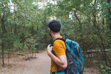  Portrait of a young backpacker man walking the forest path