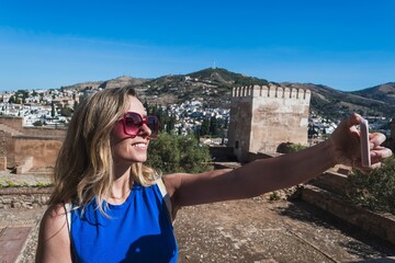 A woman is taking a selfie in front of a castle