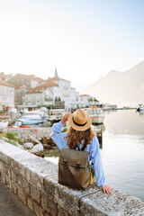 Happy young woman standing on bridge enjoys the view of the city. Back view. Europe travel. Lifestyle, vacation, tourism, nature, active life.