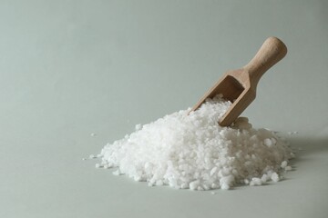 Organic salt and wooden scoop on light grey background. Space for text