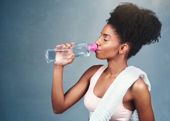 Gym, fitness and woman drinking water in studio for training, workout or intense cardio exercise on...