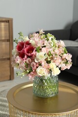 Beautiful bouquet of fresh flowers on coffee table in room