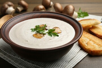 Fresh homemade mushroom soup in ceramic bowl on wooden table