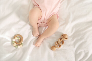 Cute baby and rattle toys on sheets, top view