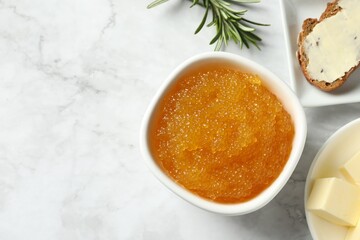 Fresh pike caviar in bowl, bread, rosemary and butter on white marble table, flat lay. Space for text