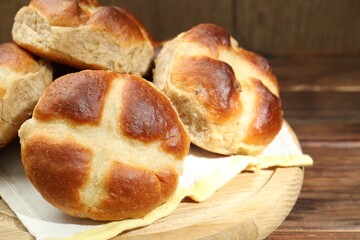 Tasty hot cross buns on wooden table, closeup
