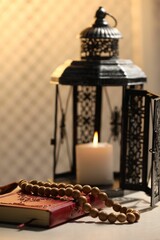 Arabic lantern, Quran and misbaha on white table