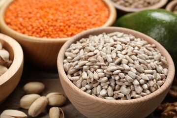 Different products high in natural fats on wooden table, closeup