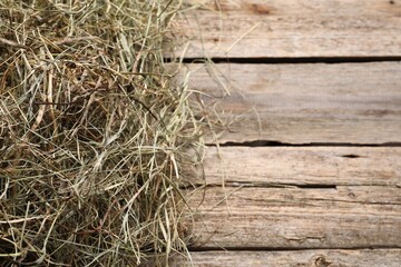 Dried hay on wooden table, above view. Space for text