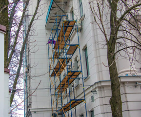 Restoration and repair of the building facade. Plasterer works on scaffolding