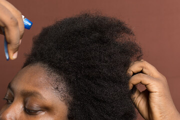 Water being sprayed on afro curly hair with shrinkage, woman with type 4c hair wetting her hair for...