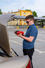 Driver with car fire extinguisher. Car fire extinguisher. A young driver.Car Equipment
