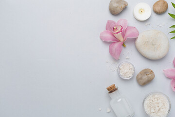 Composition with orchids and massage stones on color background, top view
