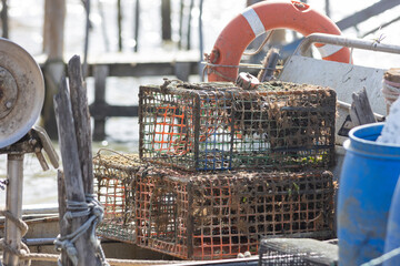 A boat with a blue container and two rusty fishing cages - trap for crabs