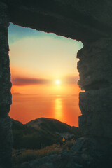 sunset over the sea by a window