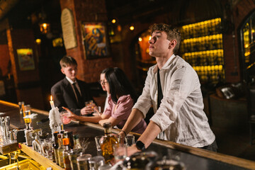 Tired young man with alcohol abuse stands by counter in bar. Exhausted office worker reduces stress...