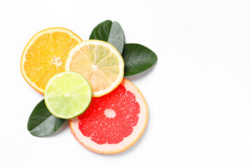 Slices of fresh ripe citrus fruits and green leaves on white background, flat lay. Space for text