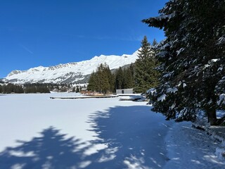 A typical winter idyll on the frozen and snow-covered alpine lake Heidsee (Igl Lai) in the Swiss winter resorts of Valbella and Lenzerheide - Canton of Grisons, Switzerland (Schweiz)