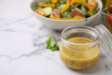 Tasty vinegar based sauce (Vinaigrette) in jar on white marble table, closeup. Space for text