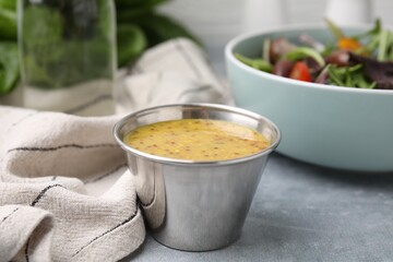 Tasty vinegar based sauce (Vinaigrette) in bowl on grey table, closeup