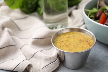 Tasty vinegar based sauce (Vinaigrette) in bowl on grey table, closeup. Space for text