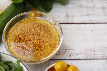 Tasty vinegar based sauce (Vinaigrette) in bowl and products on wooden rustic table, above view....