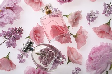 Luxury perfumes on spring floral decor, top view
