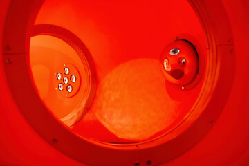 Inside of a red tubular play structure for kids climbing, nobody