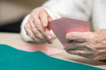 Active retirement, group of elderly women having fun playing cards game at nursing home. High quality photography.