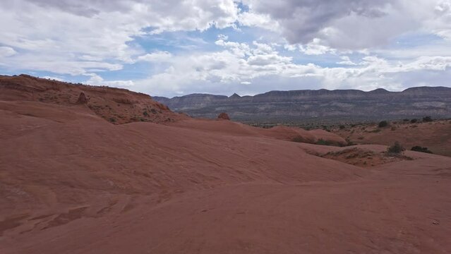 Walking across the sandstone in the Escalante desert as the wind blows.