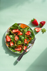 Spring light salad with strawberries, asparagus, carrots, arugula leaves, spinach and flax seeds,...