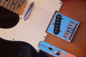 close up of electric guitar brown with white scratch plate and chrome hardware