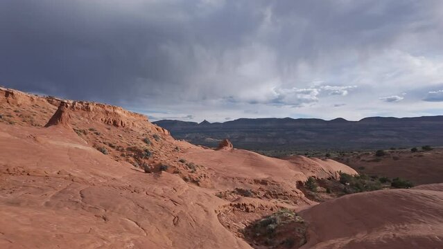 Panning view of the Escalante desert as the sandstone glows as storm moves in the background.