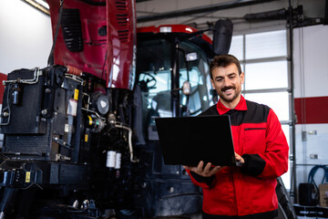 Professional serviceman holding diagnostic tool and servicing tractor.