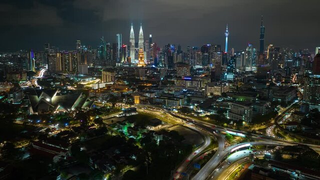 night time illumination flight over kuala lumpur central cityscape traffic road junction aerial panorama 4k timelapse malaysia