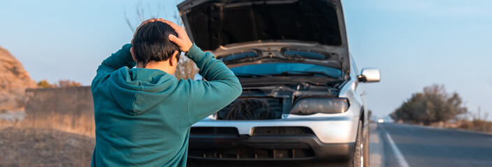 the man opened the hood of his damaged car. stock photo