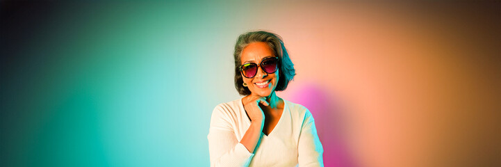 portrait of a woman wearing sunglasses on a color light background