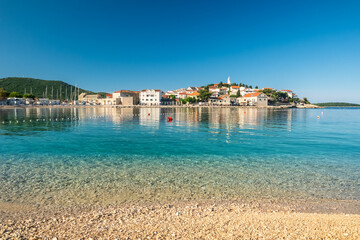Idyllic beach near the charming Primosten town, Adriatic Sea in Croatia - obrazy, fototapety, plakaty